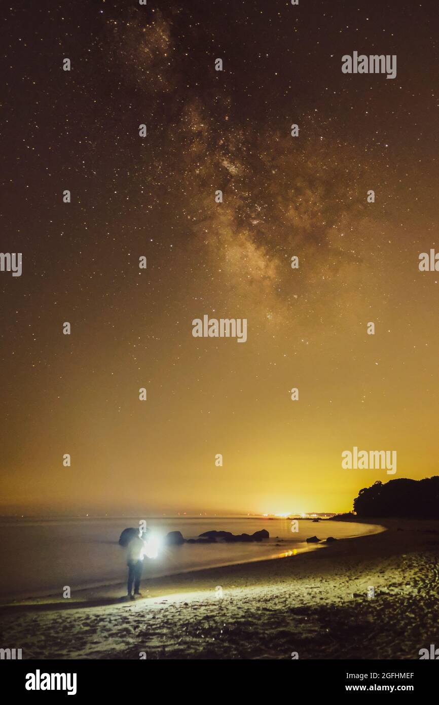 Ciel étoilé et chemin laiteux sur la côte à Kyushu. Un homme et une manière laiteuse Banque D'Images