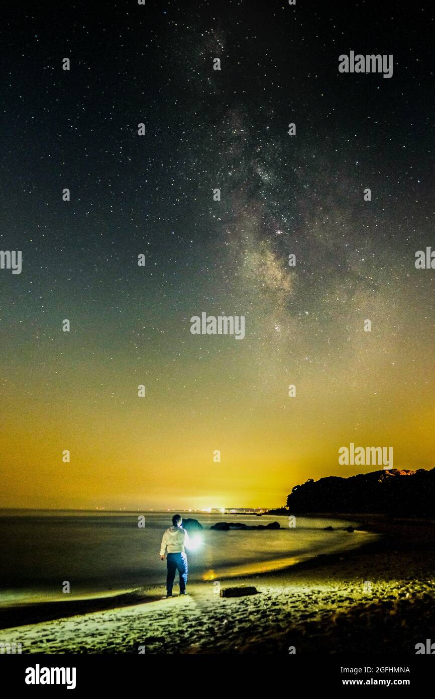 Ciel étoilé et chemin laiteux sur la côte à Kyushu. Un homme et une manière laiteuse Banque D'Images