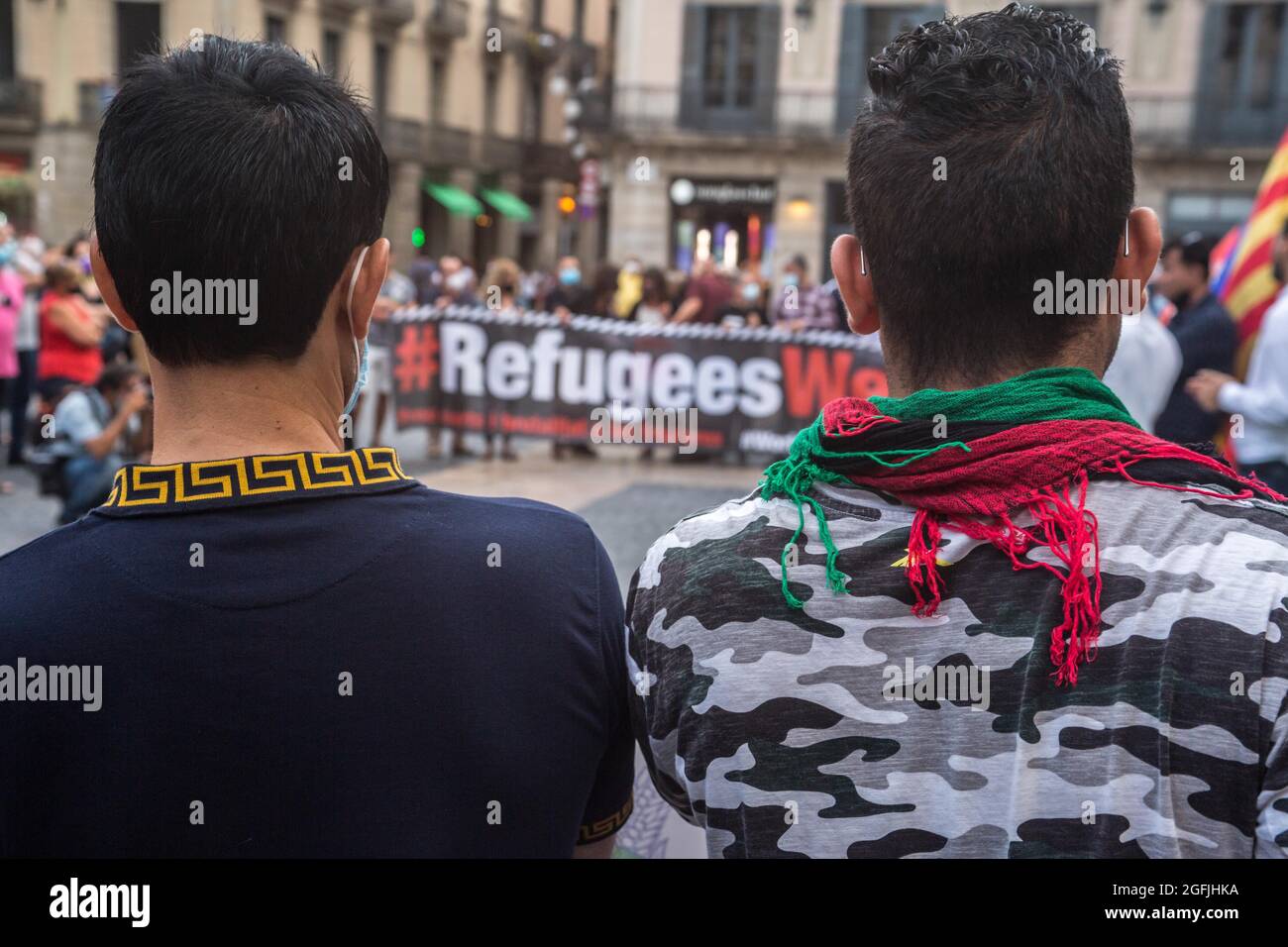 Barcelone, Espagne. 25 2021 août : des manifestants sont vus devant un panneau qui dit réfugiés Bienvenue. L'association afghane de Barcelone a manifesté devant la Generalitat de Catalogne pour demander au gouvernement la protection et l'évacuation de leurs familles qui sont restées en Afghanistan. Crédit : DAX Images/Alamy Live News Banque D'Images