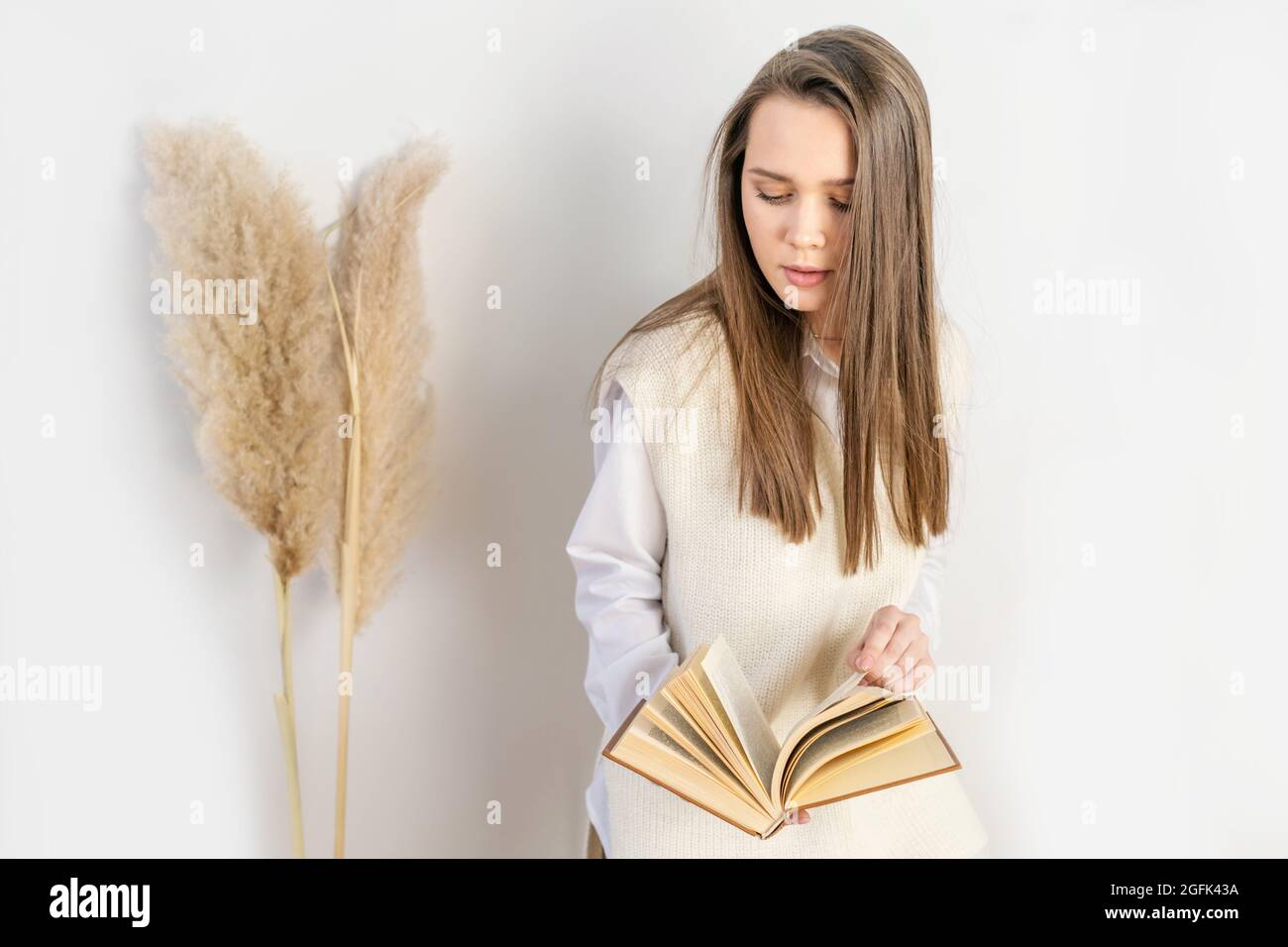 Femme avec livre sur fond blanc. Concept d'automne, prise de vue en studio. Banque D'Images