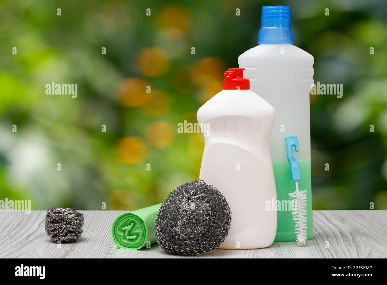 Bouteilles en plastique de liquide vaisselle, détergent pour fours à  micro-ondes et poêles, éponges métalliques et sacs à ordures sur le fond  naturel flou. Était Photo Stock - Alamy