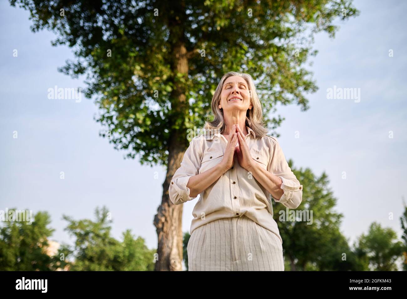 Femme souriante tenant les paumes devant elle Banque D'Images