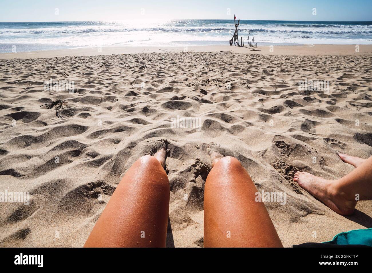 deux jambes de femmes dans le sable sur la plage Banque D'Images