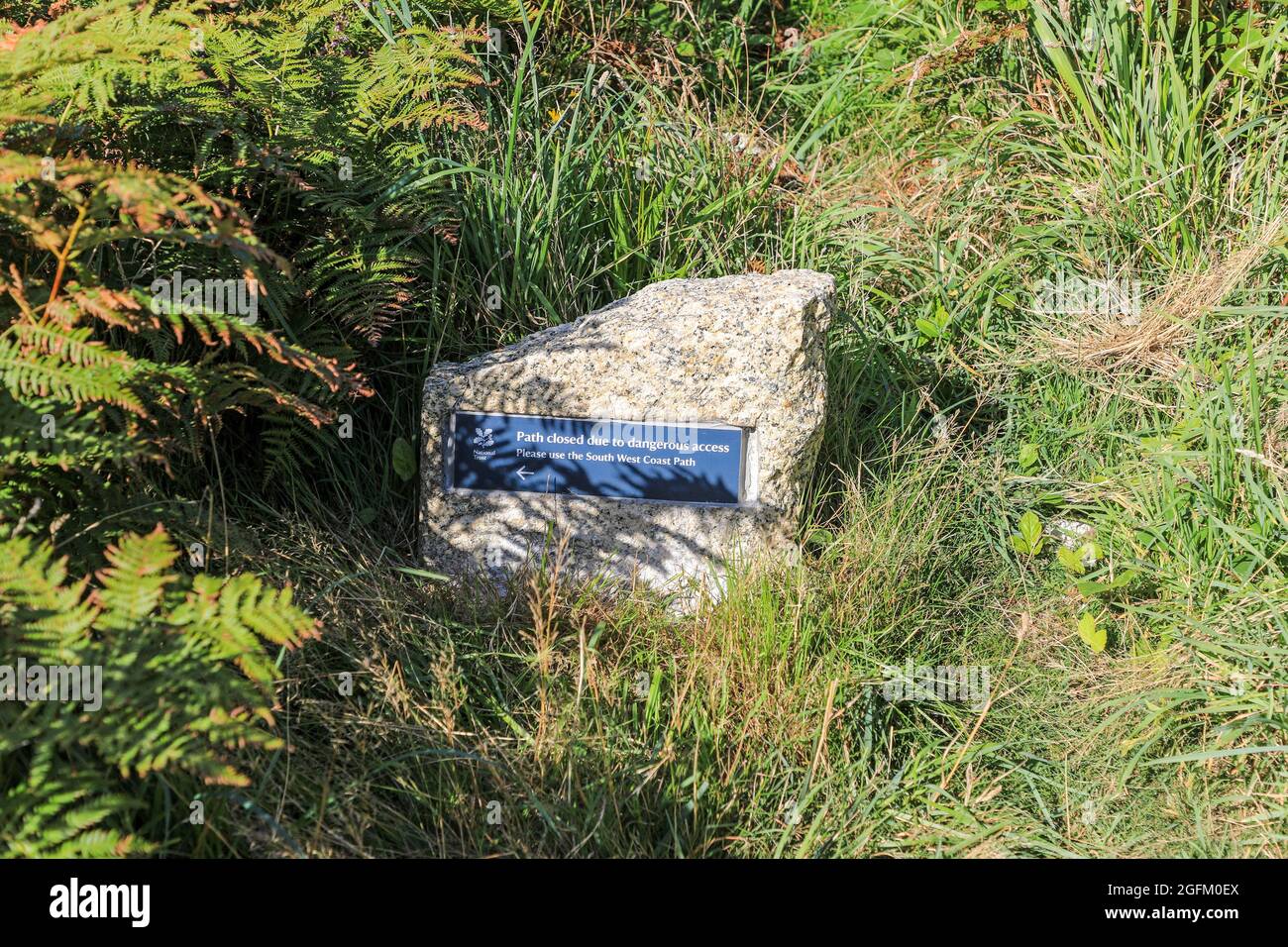 Un panneau érigé par le National Trust disant "chemin fermé, utiliser le South West Coast path", Cornwall, Angleterre, Royaume-Uni. Photo prise à partir de la piste de marche publique Banque D'Images