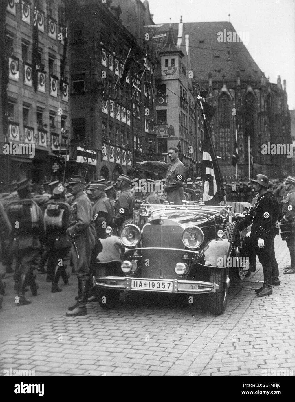 Hitler se tenait dans une voiture qui saluait les nazis alors qu'il regarde les troupes de sa (chemises brunes) défiler à Nuremberg en 1935 Banque D'Images