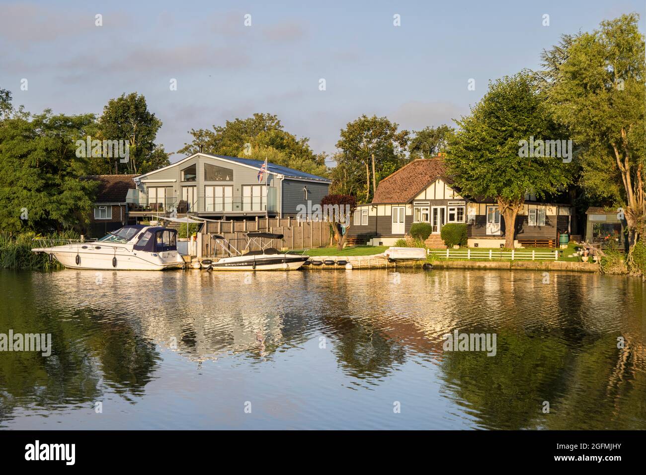 bateaux amarrés et maisons sur les rives de la tamise à laleham dans surrey Banque D'Images