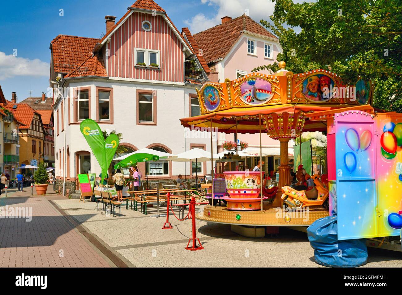 Bensheim, Allemagne - août 2021 : carrousel coloré et kiosque d'information pour les partis politiques dans le centre historique de la ville le jour d'été ensoleillé Banque D'Images