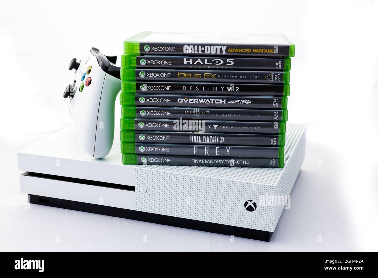 Suffolk, Royaume-Uni juin 01 2020: Une console de jeu Microsoft Xbox One S  avec une manette sans fil et une pile de jeux tournés sur un fond blanc Uni  Photo Stock - Alamy