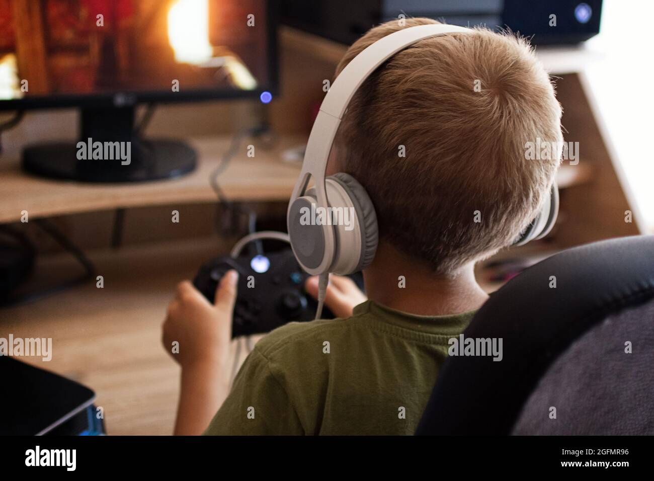 Petit garçon dans les hearphones jouant avec joystick dans x box.Generation Z et alpha. Banque D'Images