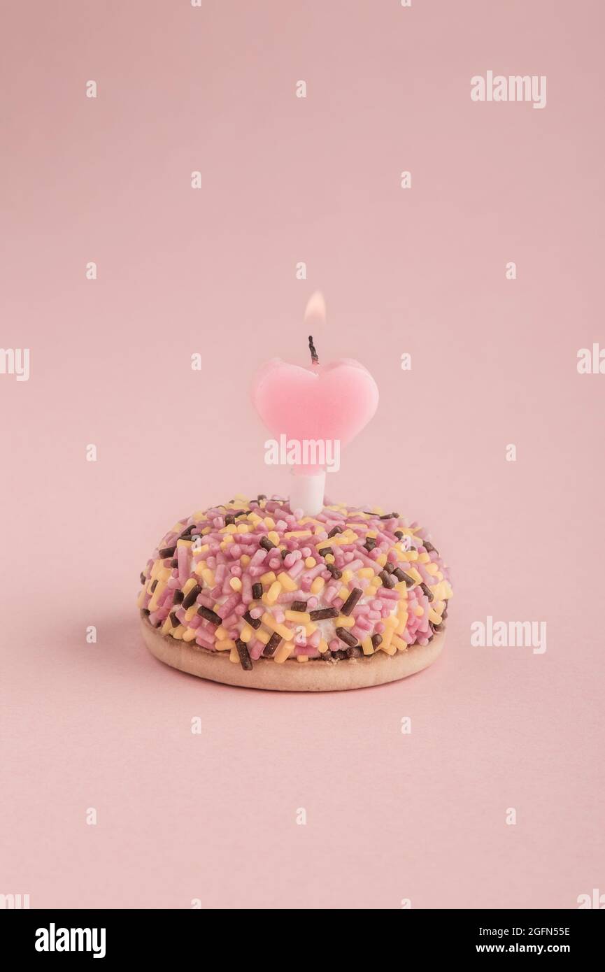 Un Petit Gateau D Anniversaire Colore Avec Coeur En Forme De Bougie Sur Rose Photo Stock Alamy