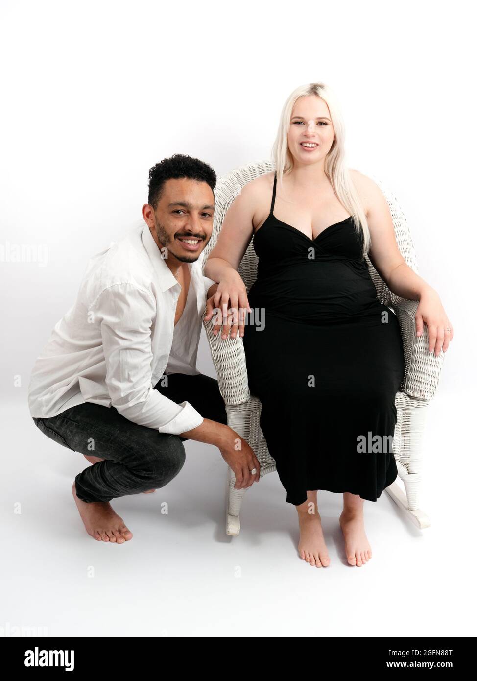 Portrait vertical d'un couple multiethnique élégant et heureux qui attend un bébé Banque D'Images