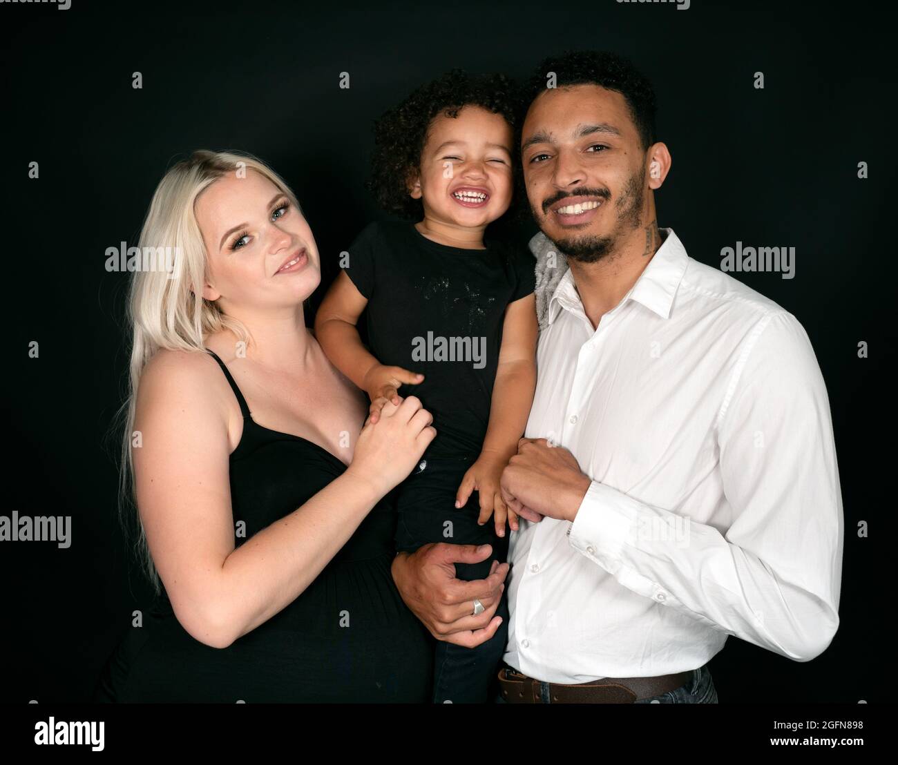 Portrait d'une famille multi-ethnique élégante et heureuse qui attend un bébé Banque D'Images