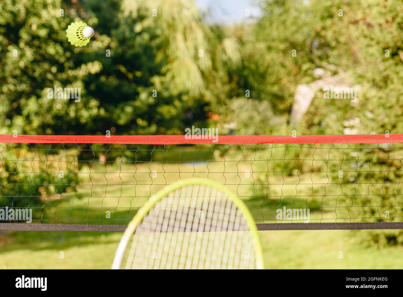 Badminton décontracté dans le jardin concept avec shuttlecock survolant le filet  et la raquette prêt à partir Photo Stock - Alamy