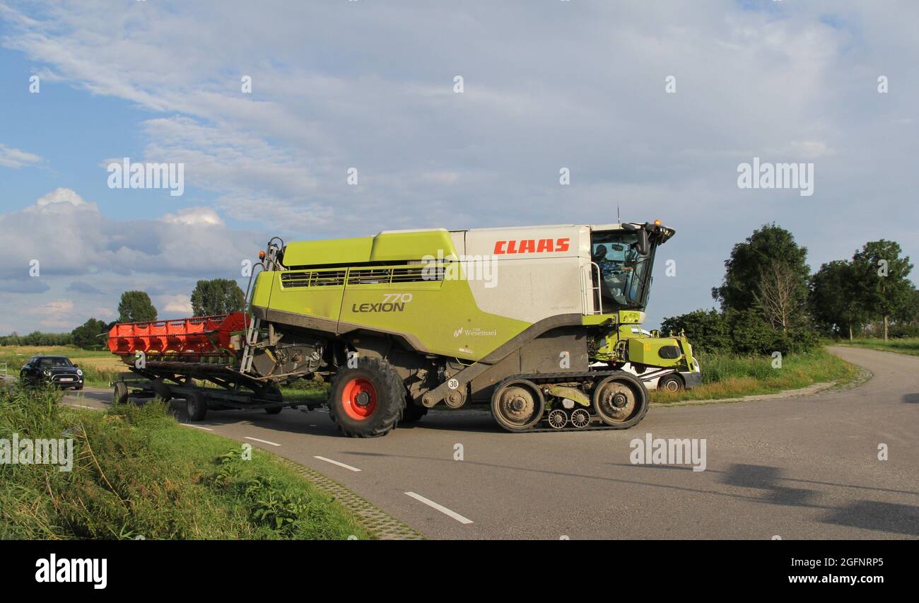en été, une grande moissonneuse-batteuse se trouve sur une route de campagne dans la campagne hollandaise Banque D'Images