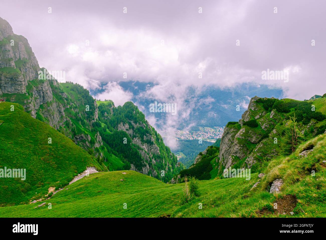 Photographie de paysage d'un ravin dans les montagnes en été avec des nuages et un temps brumeux. La photographie a été prise à côté de la cabine de Caraiman, en Roumanie Banque D'Images