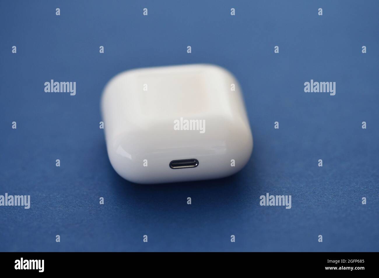 Photo de l'étui de chargement des écouteurs intelligents sans fil sur fond bleu Banque D'Images