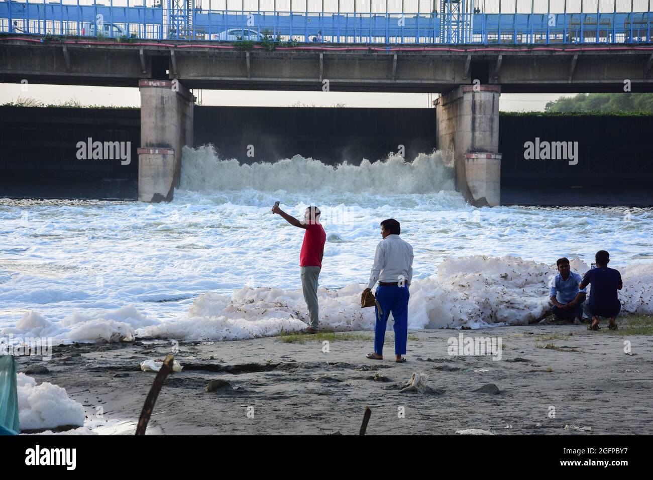 New Delhi, Inde. 26 août 2021. Les gens prennent des photos à côté des eaux fortement polluées de la rivière Yamuna avec une épaisse couche blanche de mousse toxique montrant des niveaux élevés de pollution de l'eau. (Photo de Manish Rajput/SOPA Images/Sipa USA) Credit: SIPA USA/Alay Live News Banque D'Images