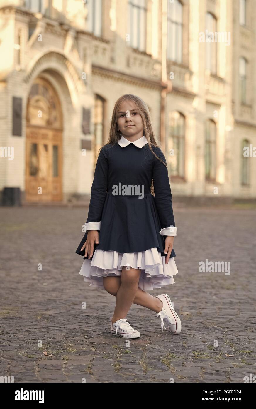 La pratique est parfaite. Un petit enfant fait des petites fleurs en plein air. Petite ballerine porter uniforme. Retour a la mode scolaire. Tenue habillee. 1er septembre. Retour a Photo Stock