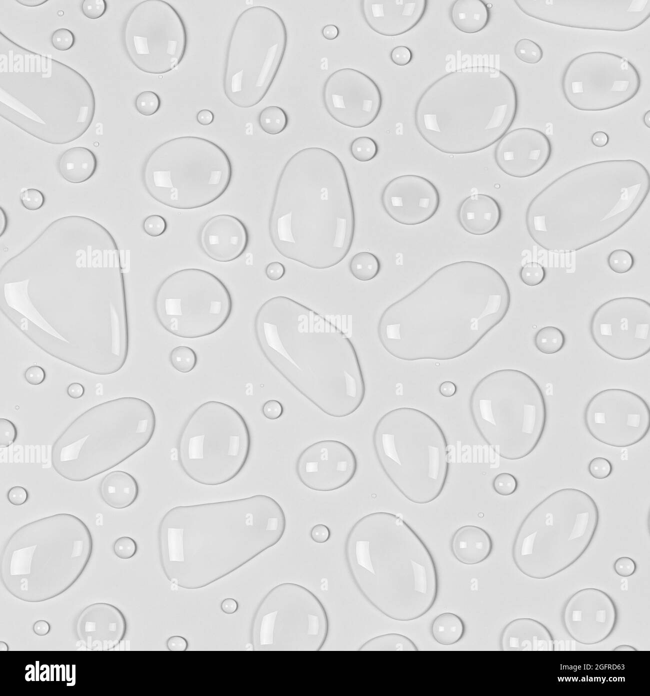 L'eau tombe sur un fond blanc ou gris clair. Gros plan sur la texture de l'eau. Toile de fond verre recouvert de gouttes d'eau. Bulles d'eau. Banque D'Images