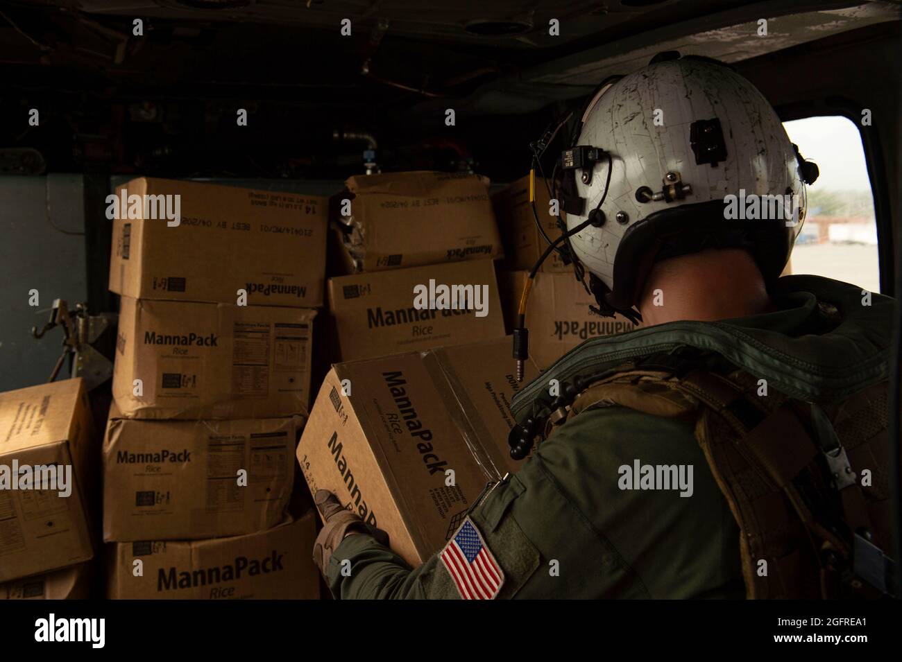 210825-N-MD802-1695 PORT-AU-PRINCE - (AOÛT 25, 2021) — Marine Aircrewman (hélicoptère) de 2e classe Cameron Brown, affecté aux “Chargers” de l’Escadron de combat de la mer (HSC) 26, charge des boîtes de nourriture à bord d’un hélicoptère MH-60S Sea Hawk, au cours d’une mission d’aide humanitaire soutenant l’Agence américaine pour le développement international (USAID), le 25 août 2021. HSC-26 est attaché au quai de transport amphibie de classe San Antonio USS Arlington (LPD 24). Arlington est déployé au Commandement Sud des forces navales américaines/États-Unis 4e flotte pour soutenir les efforts d'aide humanitaire et de secours en cas de catastrophe (HADR) Banque D'Images