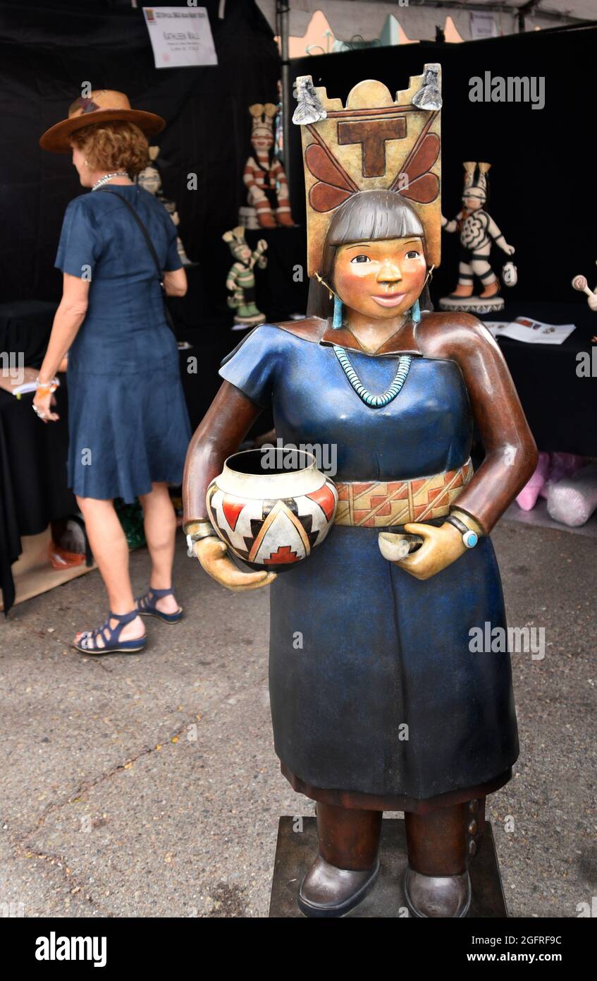 Une femme visite le stand de l'artiste d'argile autochtone d'Amérique Kathleen Wall, qui vend ses sculptures au marché indien de Santa Fe, au Nouveau-Mexique. Banque D'Images