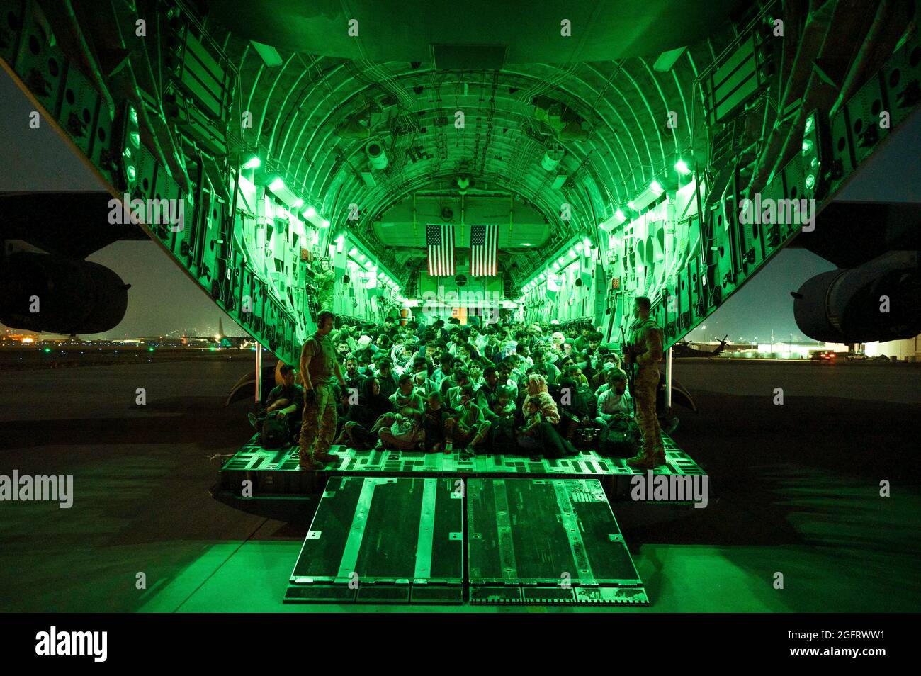 Un équipage de la Force aérienne des États-Unis, affecté au 816e Escadron de transport aérien expéditionnaire, aide les évacués qualifiés à bord d'un avion C-17 Globemaster III de la Force aérienne des États-Unis à l'appui de l'évacuation en Afghanistan à l'aéroport international Hamid Karzaï, en Afghanistan, le 21 août 2021. Le ministère de la Défense s'est engagé à appuyer le département d'État des États-Unis dans le départ du personnel civil américain et allié d'Afghanistan et à évacuer les alliés afghans en toute sécurité. (É.-U. Photo de la Force aérienne par Airman Taylor Crul via American PhotoArchive/Alamy) Banque D'Images