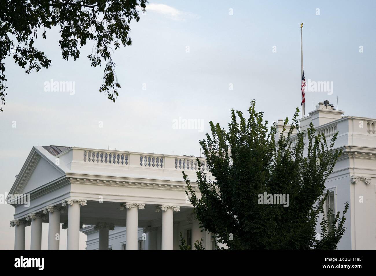 Le drapeau américain vole à la moitié du personnel à la Maison Blanche à Washington, DC, Etats-Unis le jeudi 26 août 2021. Plusieurs explosions près de l'aéroport international Hamid Karzaï de Kaboul, en Afghanistan, ont blessé beaucoup et tué au moins 12 membres du service américain. Crédit: Stefani Reynolds / piscine via CNP Banque D'Images