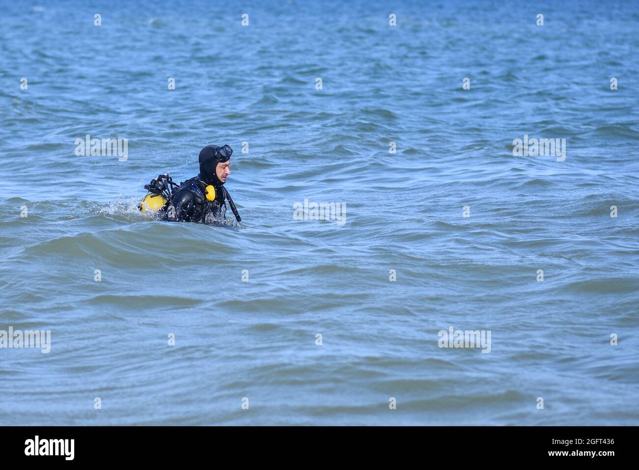 un homme en costume de plongée entre dans l'eau. Éditorial Banque D'Images