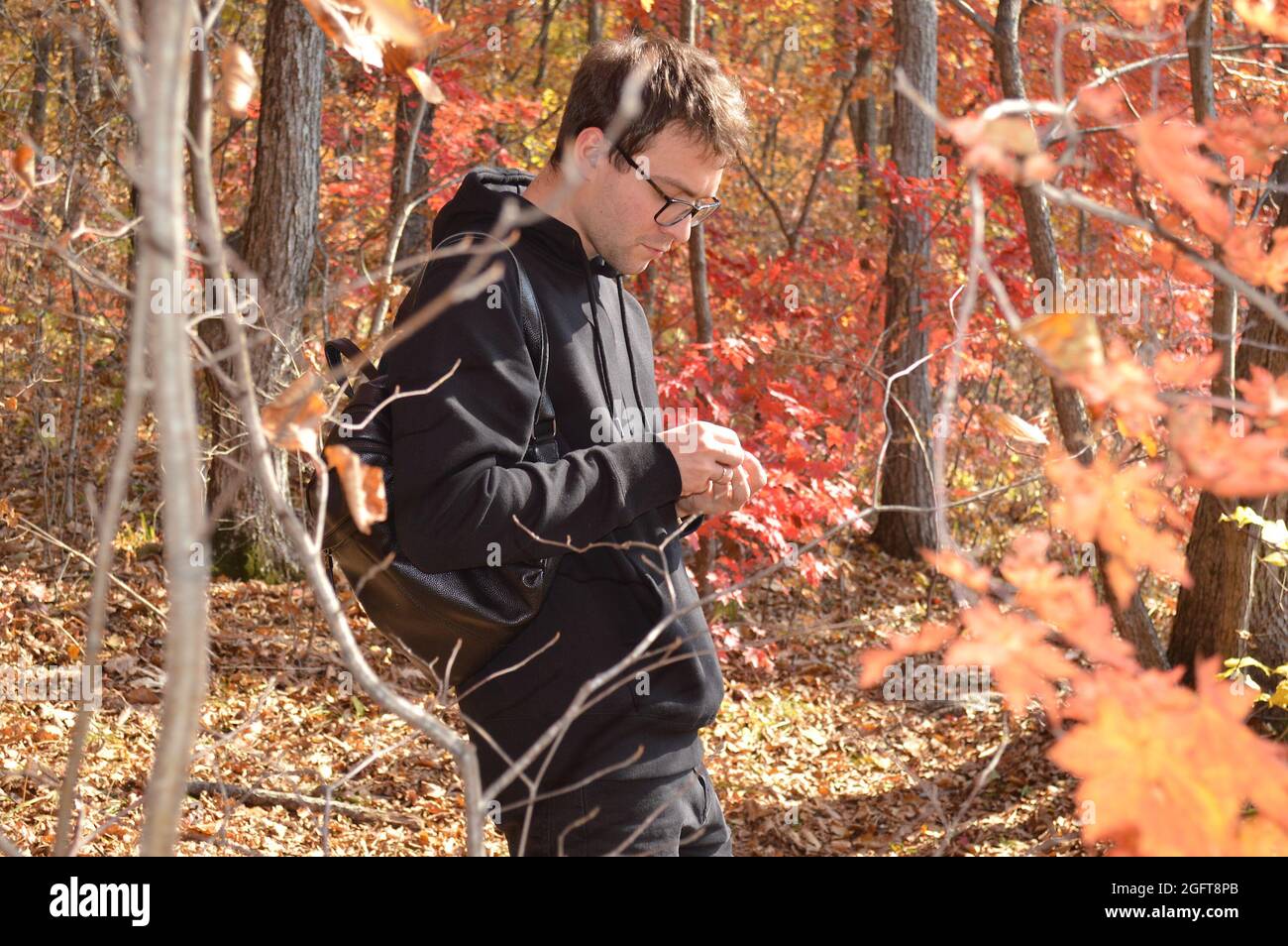 Portrait du jeune homme russe marchant dans la forêt d'automne et explorant la nature Banque D'Images