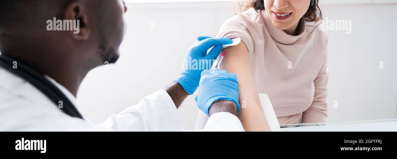 African American Doctor Giving Woman Vaccine Treatment Banque D'Images
