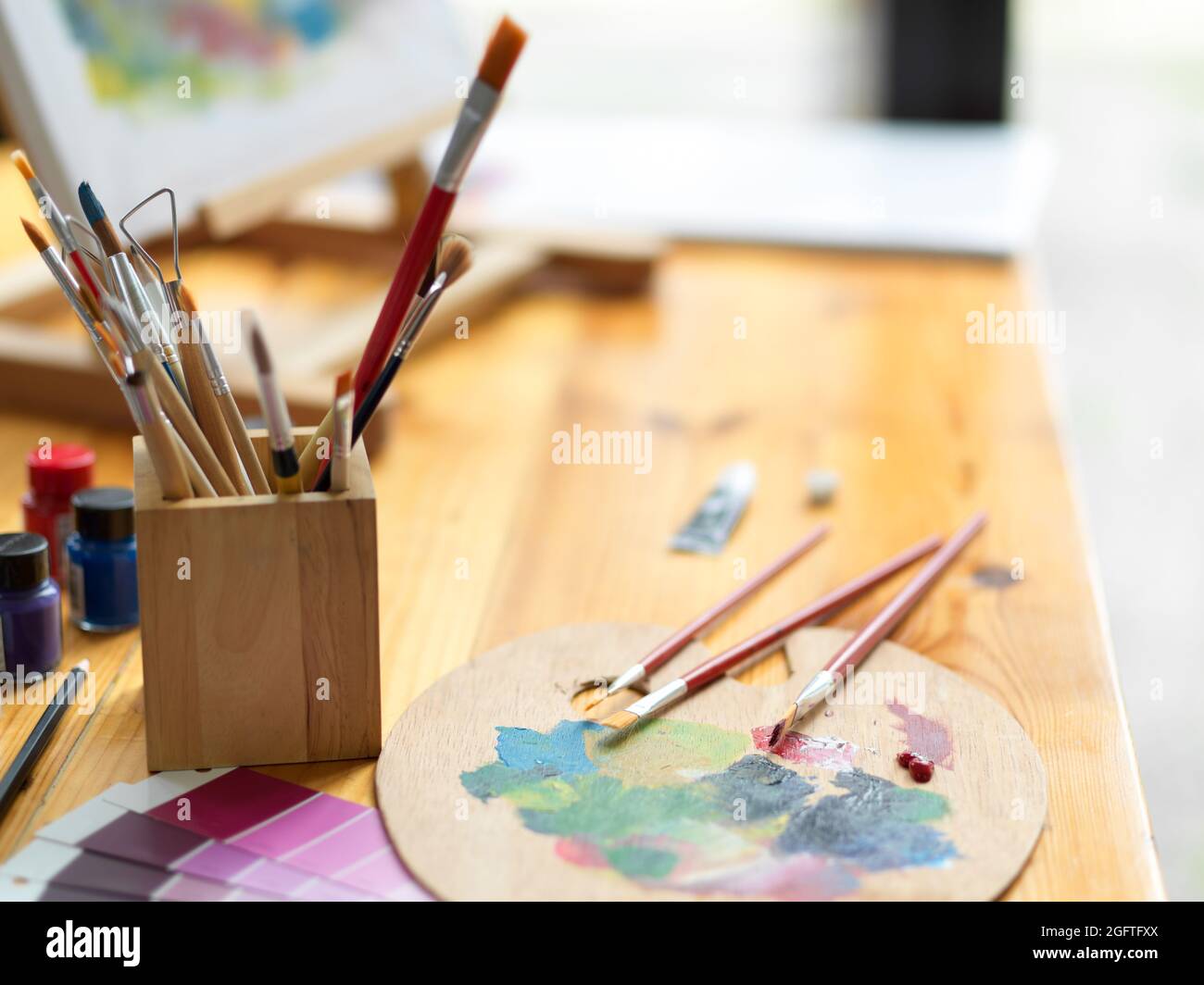 Gros plan, vue latérale, outils de peinture artiste, pinceaux, palette de couleurs, échantillon de nuance de couleur, couleur acrylique sur table en bois Banque D'Images Gros plan, vue latérale, outils de peinture artiste, pinceaux, palette de couleurs, échantillon de nuance de couleur, couleur acrylique sur table en bois Banque D'Images