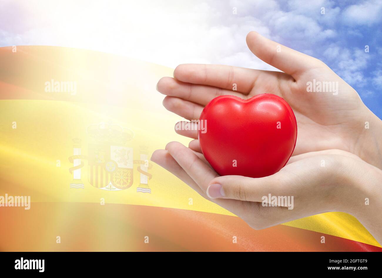 Les mains de l'enfant tiennent un coeur sur le fond du drapeau de  l'Espagne, concept de soins de santé Photo Stock - Alamy