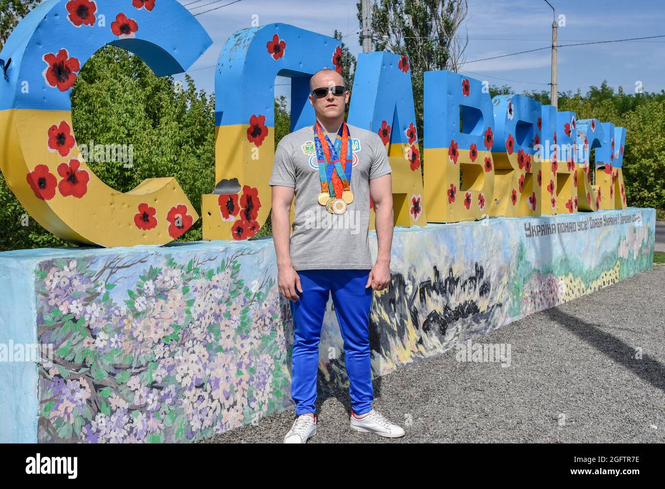 Oleksandr Mashchenko, champion paralympique de l'équipe de natation ukrainienne, porte ses médailles à l'entrée de Slavyansk pendant la séance photo. Banque D'Images