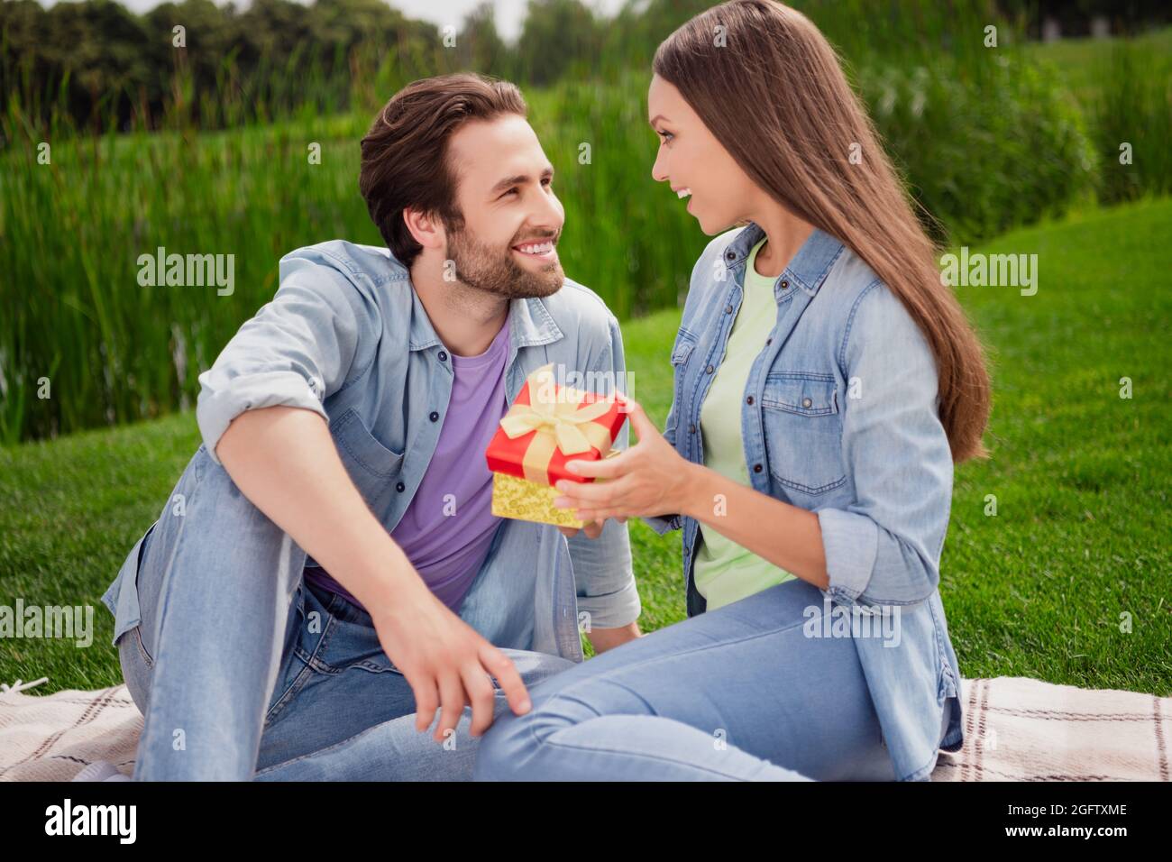 Photo de bonne humeur couple gaie femme et mari ont pique-nique à l'extérieur appréciez week-end célébration femme anniversaire boîte cadeau Banque D'Images