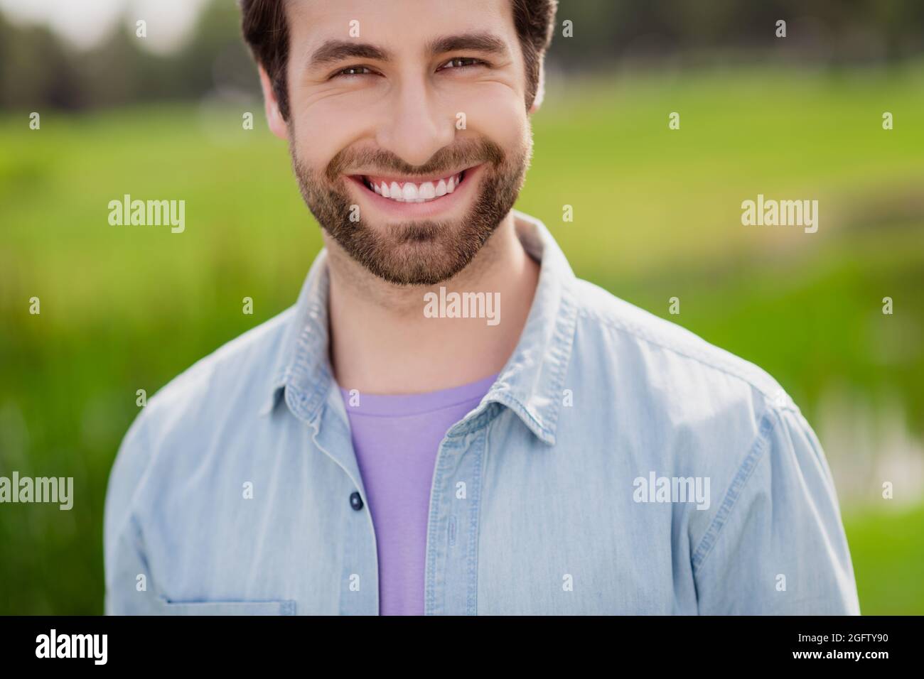 Photo de jeune beau gai positif homme relaxant temps libre week-end vêtements en denim chemise temps plein air Banque D'Images