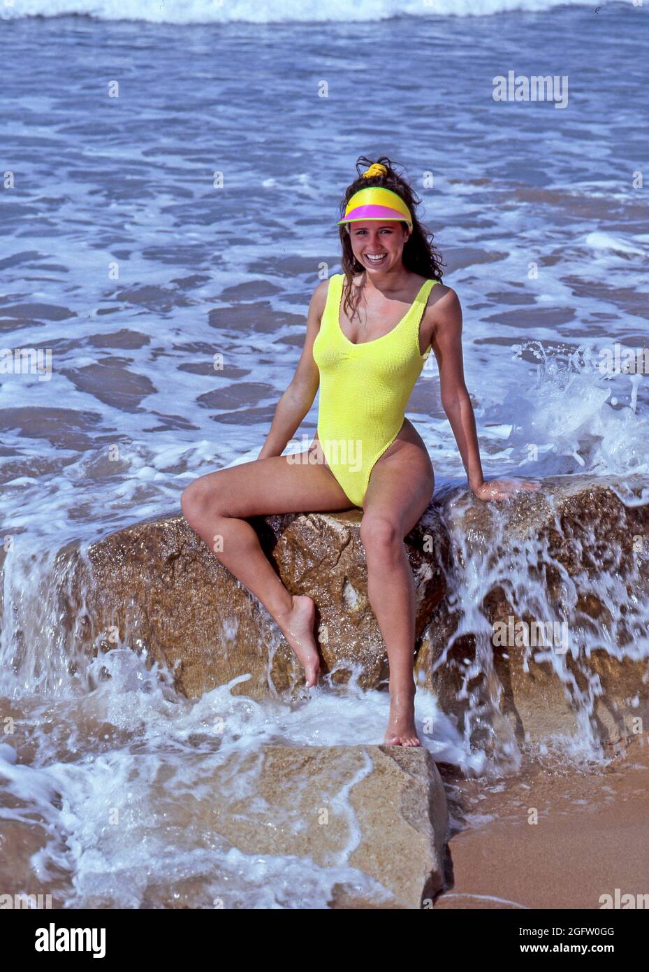 Archive 1991 vue de la femme souriante maillot de bain modèle de mode  posant sur des rochers dans les vagues de mer sur le rivage chaud jour  ensoleillé en Algarve sur une