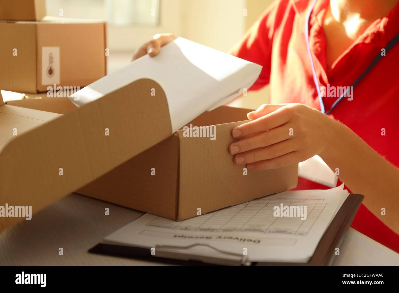 Colis d'emballage des mains de coursier sur la table Photo Stock - Alamy