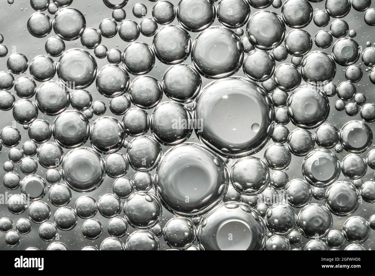 Bulles d'huile dans l'eau faisant un intéressant modèle macro gris acier Banque D'Images