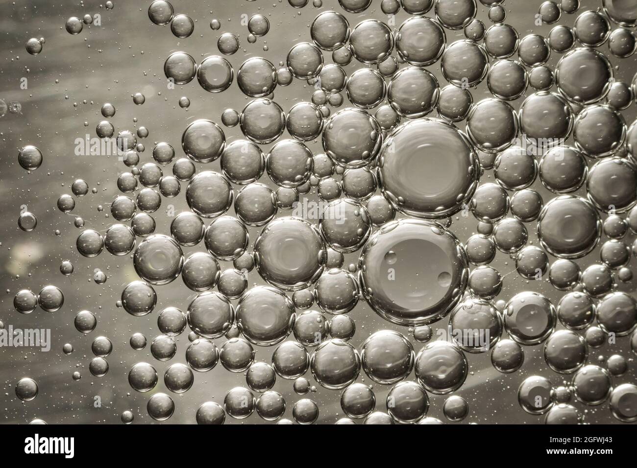 Bulles d'huile dans l'eau faisant un intéressant modèle macro gris acier Banque D'Images