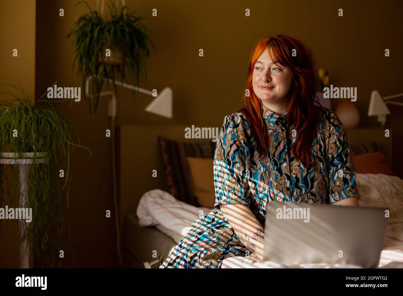 Femme au lit qui regarde loin Banque D'Images