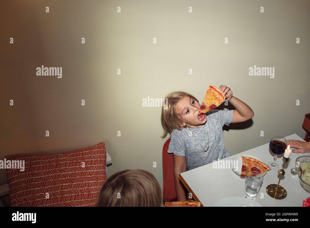 Fille à la table manger de la pizza Banque D'Images