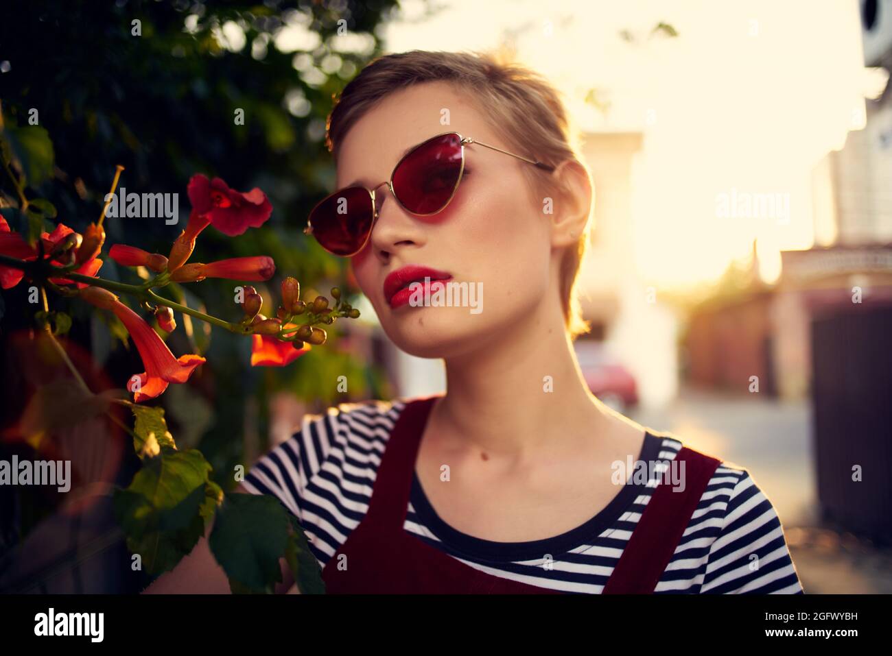 femme avec cheveux courts portant des lunettes de soleil extérieur fleurs  décoration Photo Stock - Alamy