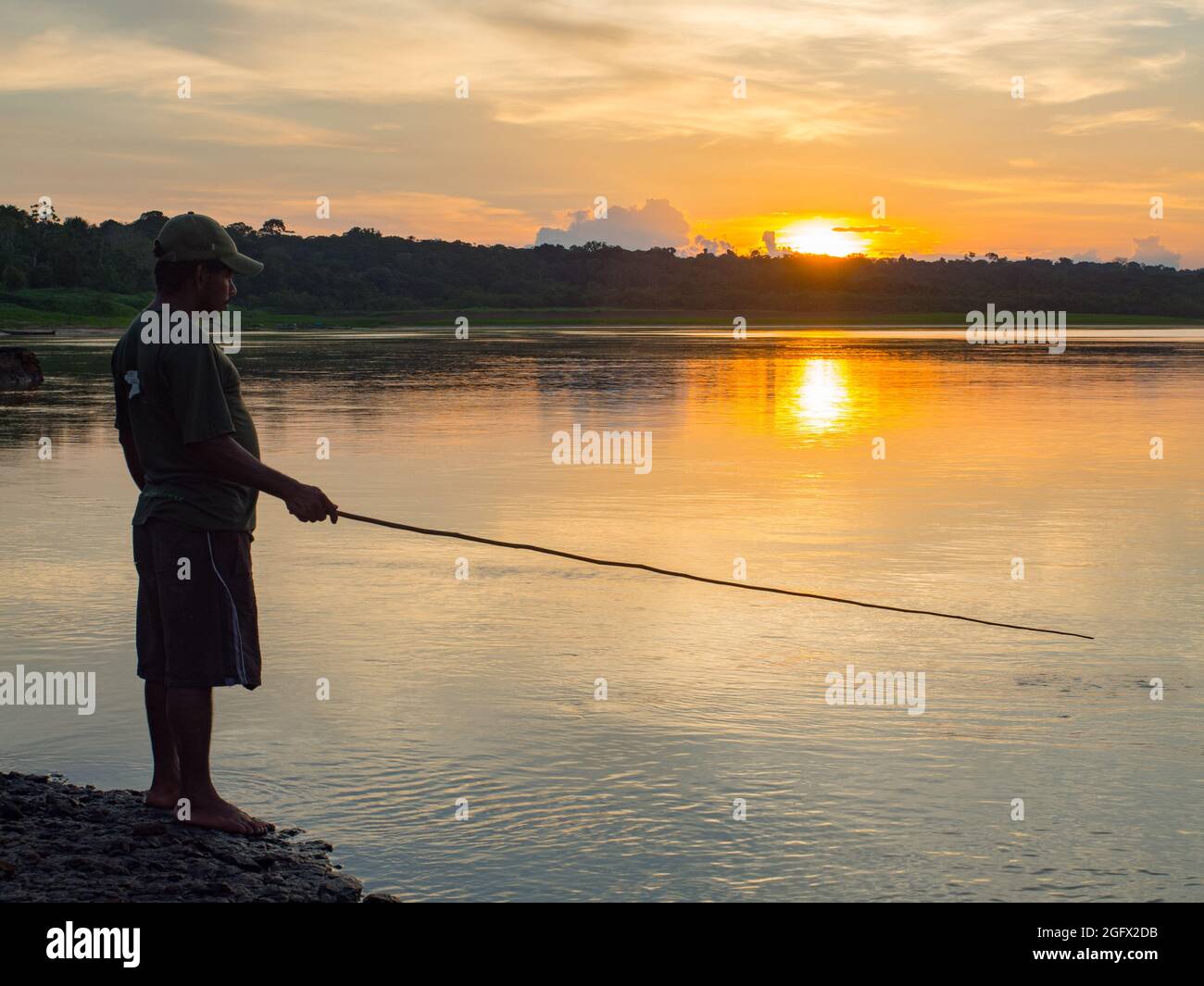 Palmari, Brésil - 2017: Résident d'une jungle amazonienne pêchant le piranha au coucher du soleil. Javari Valley, Amérique du Sud Banque D'Images