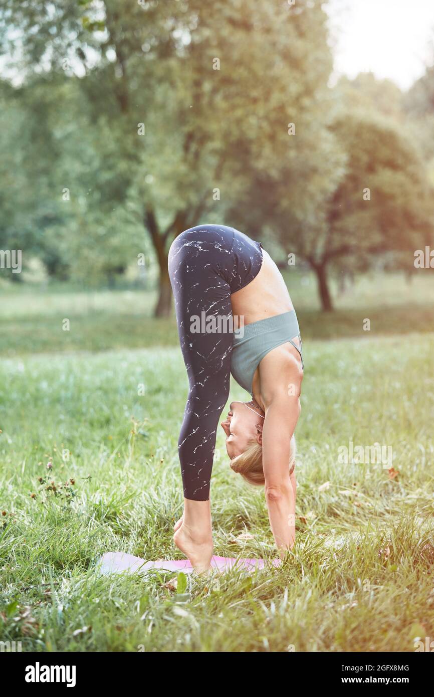 Jeune Sport blonde femme yogini pratiquer l'exercice de yoga dans le parc  le soir, le coucher du soleil. Le yoga est la méditation et le sport sain  concept Photo Stock - Alamy