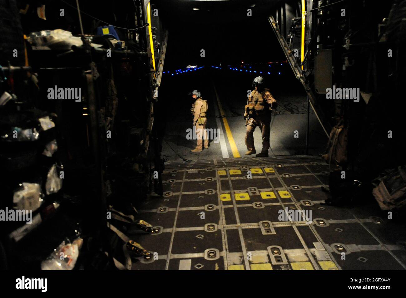 L'ancien Airman Michael Schoettlin, à gauche, et le sergent d'état-major. Mary Sierra, les deux charmeurs Hercules « combat King » HC-130P déployés au 79e Escadron de sauvetage expéditionnaire, attendent que des fournitures médicales soient livrées à l’aéronef, le 10 avril, à l’aérodrome de Kandahar, en Afghanistan. Banque D'Images