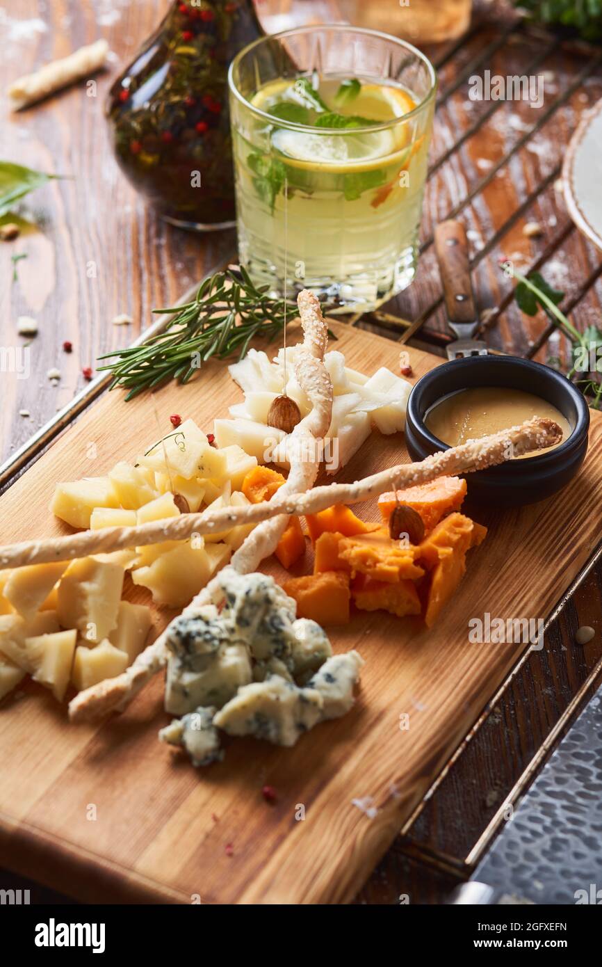 antipasti, différents types de fromage sur une planche de bois avec miel Banque D'Images