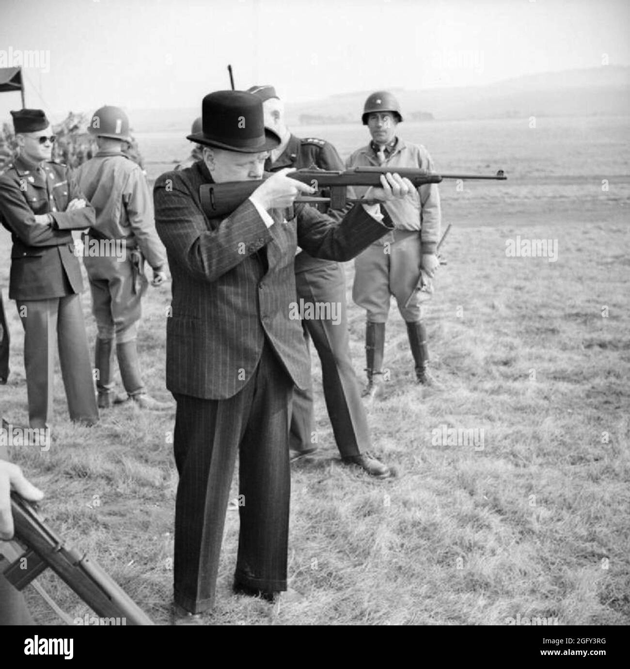 Winston Churchill tirant sur une carbine américaine 0,30 lors d'une visite à la 2e Division blindée des États-Unis sur la plaine de Salisbury, 23 mars 1944. Banque D'Images