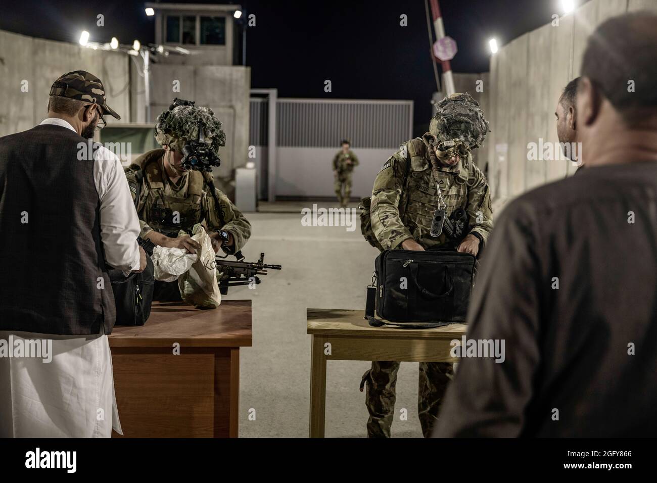 Les soldats américains de la 82e Division aéroportée vérifient les évacués lors d'une évacuation à l'aéroport international Hamid Karzaï, Kaboul, Afghanistan, le 25 août. Les membres du service américain aident le ministère d'État à effectuer une opération d'évacuation (NEO) non combattue en Afghanistan. (É.-U. Photo du corps marin par le sergent d'état-major. Victor Mancilla) Banque D'Images