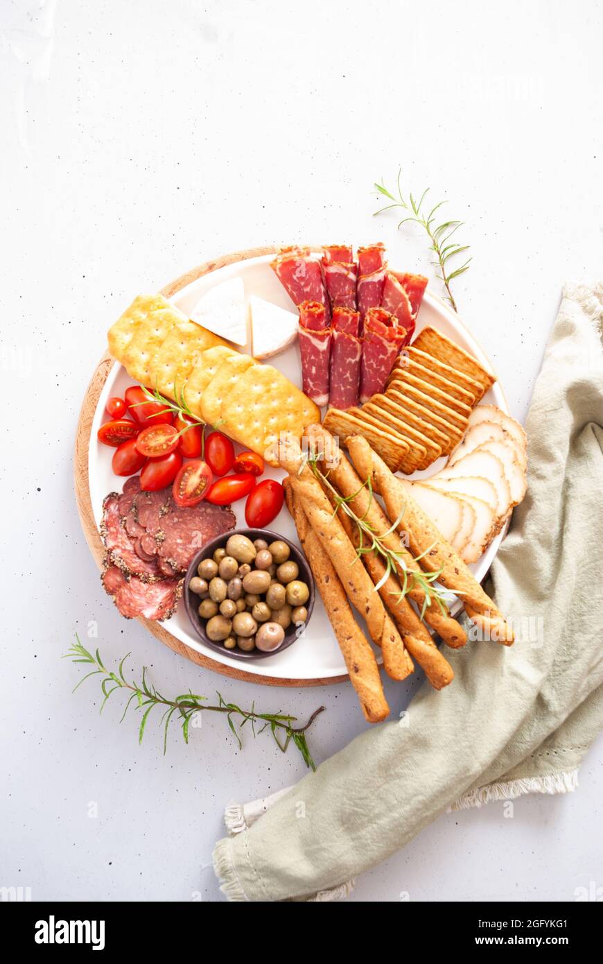 Carte de charcuterie avec fromage, salami, mini tomates, huile d'olive et  craquelins Photo Stock - Alamy