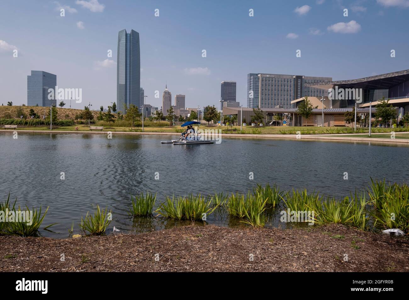 Oklahoma City, Oklahoma. Pédalo au parc Scissortail, avec Devon Tower en arrière-plan, centre de congrès d'Oklahoma City sur la droite. Banque D'Images